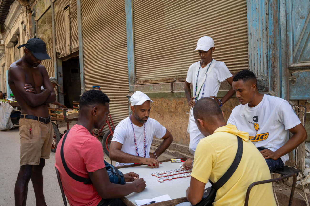 Cuba Street Photography Roadtrp | 14 Day Guide with Mark Seymour 11 “Classic Cuban street moment with friends immersed in a lively domino game.”