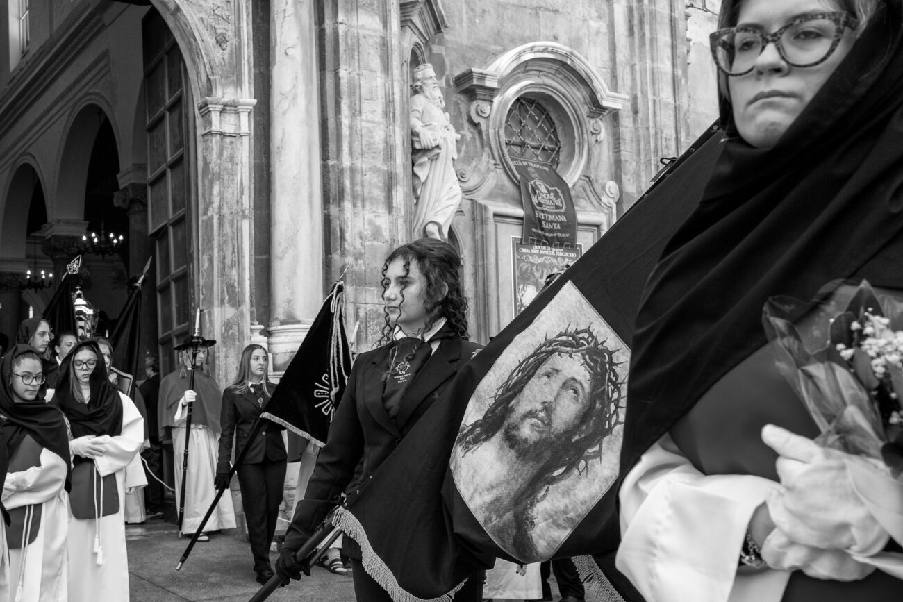 Inside the Misteri di Trapani: Documenting Sicily’s Living Tradition 4 Young members of the confraternity carrying ceremonial banners outside the Church of the Anime Sante before the Misteri di Trapani procession in Trapani, Sicily.