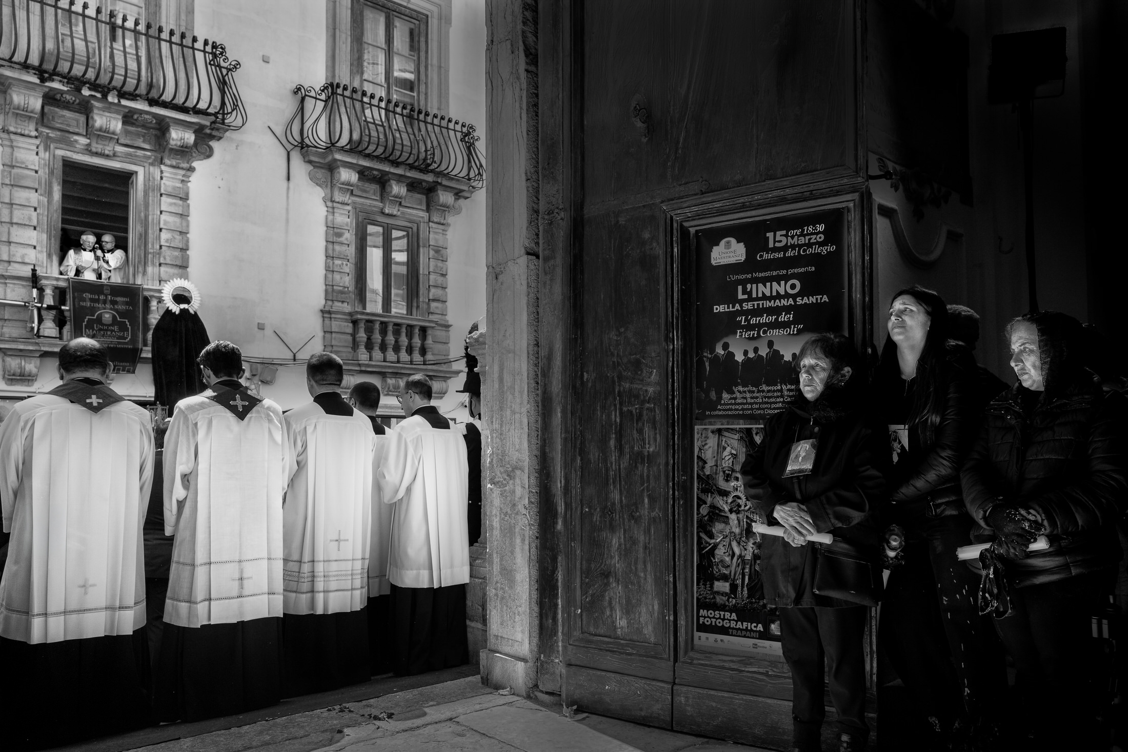 Worshippers dressed in black stand beside priests in white robes outside the Church of the Souls in Purgatory as a bishop addresses the crowd from a balcony above during the closing ceremony.