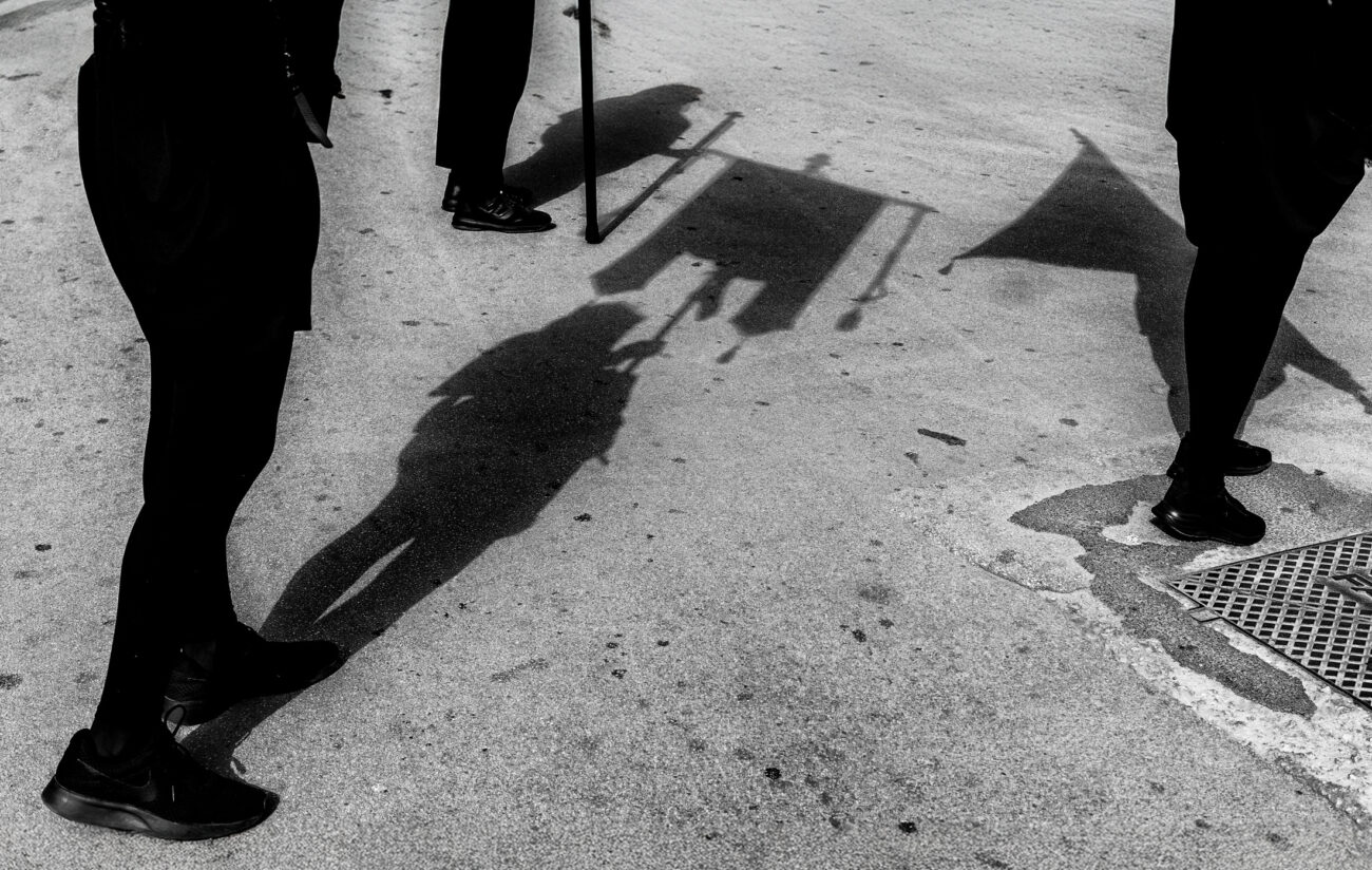 Inside the Misteri di Trapani: Documenting Sicily’s Living Tradition 23 Shadows of a Misteri procession float and banners fall across the street as participants walk through Trapani on Good Friday.