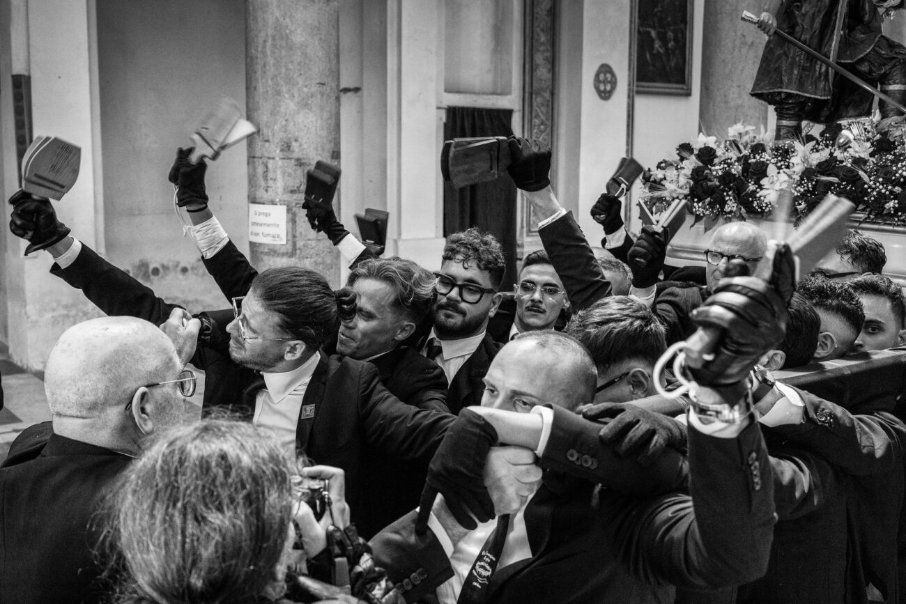 Inside the Misteri di Trapani: Documenting Sicily’s Living Tradition 27 Float bearers raise traditional wooden clappers in celebration as a Misteri procession float returns to the Church of the Souls in Purgatory in Trapani.