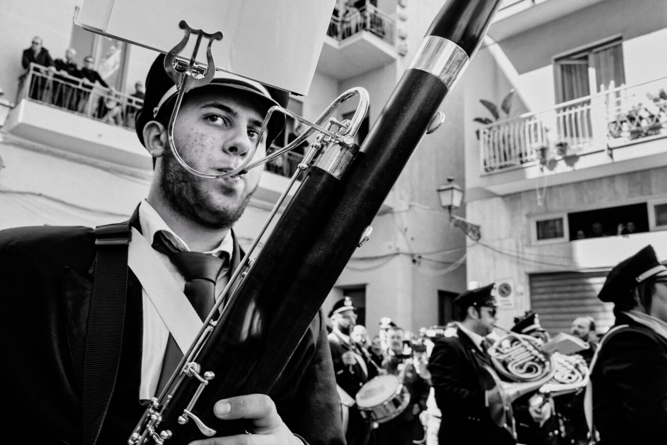 Inside the Misteri di Trapani: Documenting Sicily’s Living Tradition 22 A young bassoon player performs in the band during the Misteri di Trapani procession, his face framed by the curved metal bocal of the instrument.