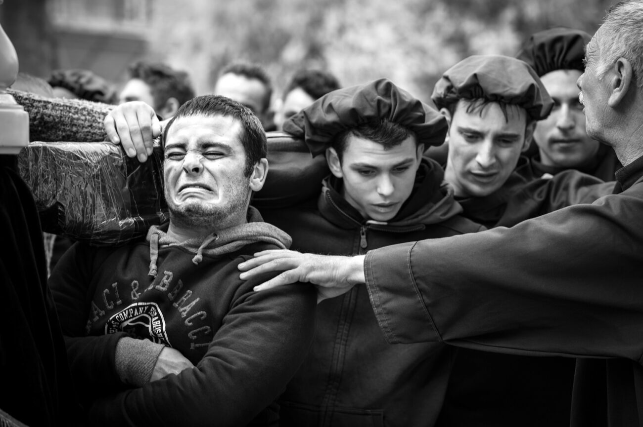 Inside the Misteri di Trapani: Documenting Sicily’s Living Tradition 19 A young bearer grimaces under the weight of a sacred group during the Misteri di Trapani procession in Trapani, Sicily.
