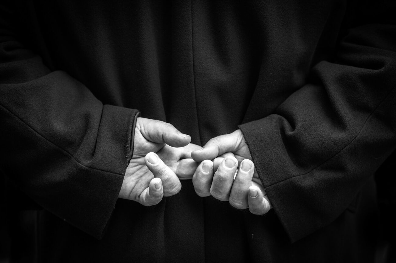 Inside the Misteri di Trapani: Documenting Sicily’s Living Tradition 26 Close-up of a participant's clasped hands beneath a dark ceremonial robe while waiting to take part in the Misteri di Trapani procession.