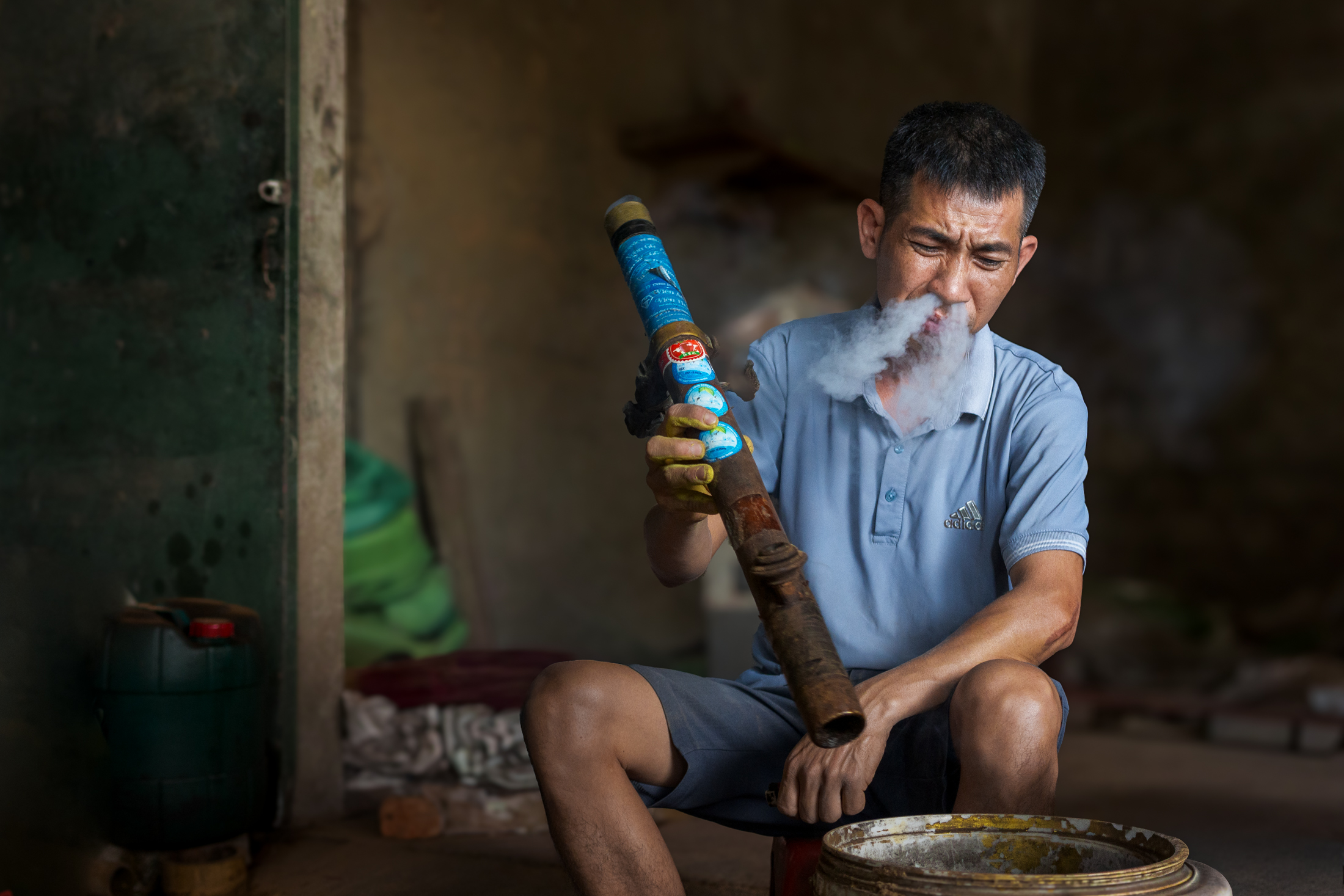 Northern Vietnam Photography: A Photographer’s Journey Beyond the Tourist Trail 30 A man smokes a traditional bamboo water pipe inside his home in northern Vietnam.