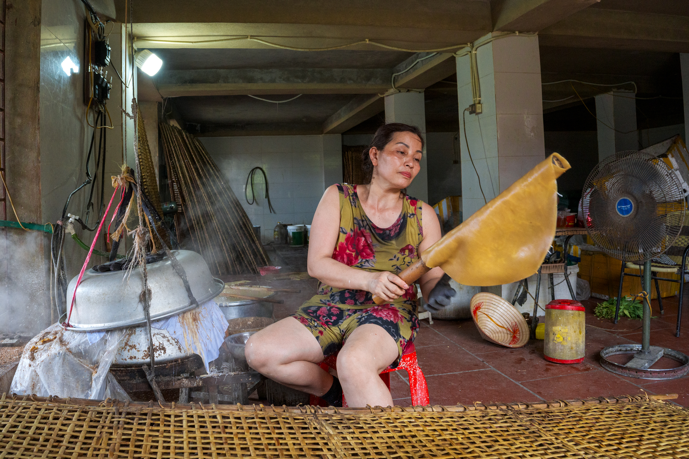 Northern Vietnam Photography: A Photographer’s Journey Beyond the Tourist Trail 13 A woman prepares and dries traditional rice crackers inside a family workshop in a craft village near Hanoi, Vietnam.