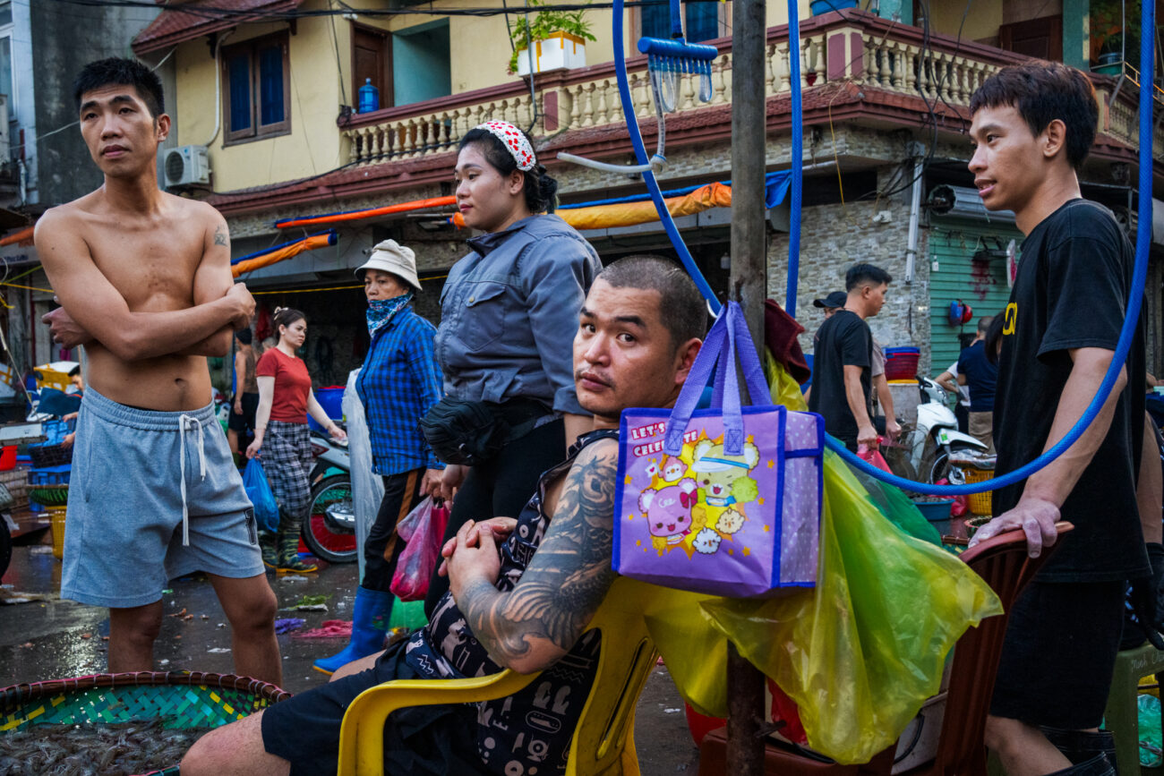 Northern Vietnam Photography: A Photographer’s Journey Beyond the Tourist Trail 1 Young men and traders at Long Bien Market in Hanoi, Vietnam.