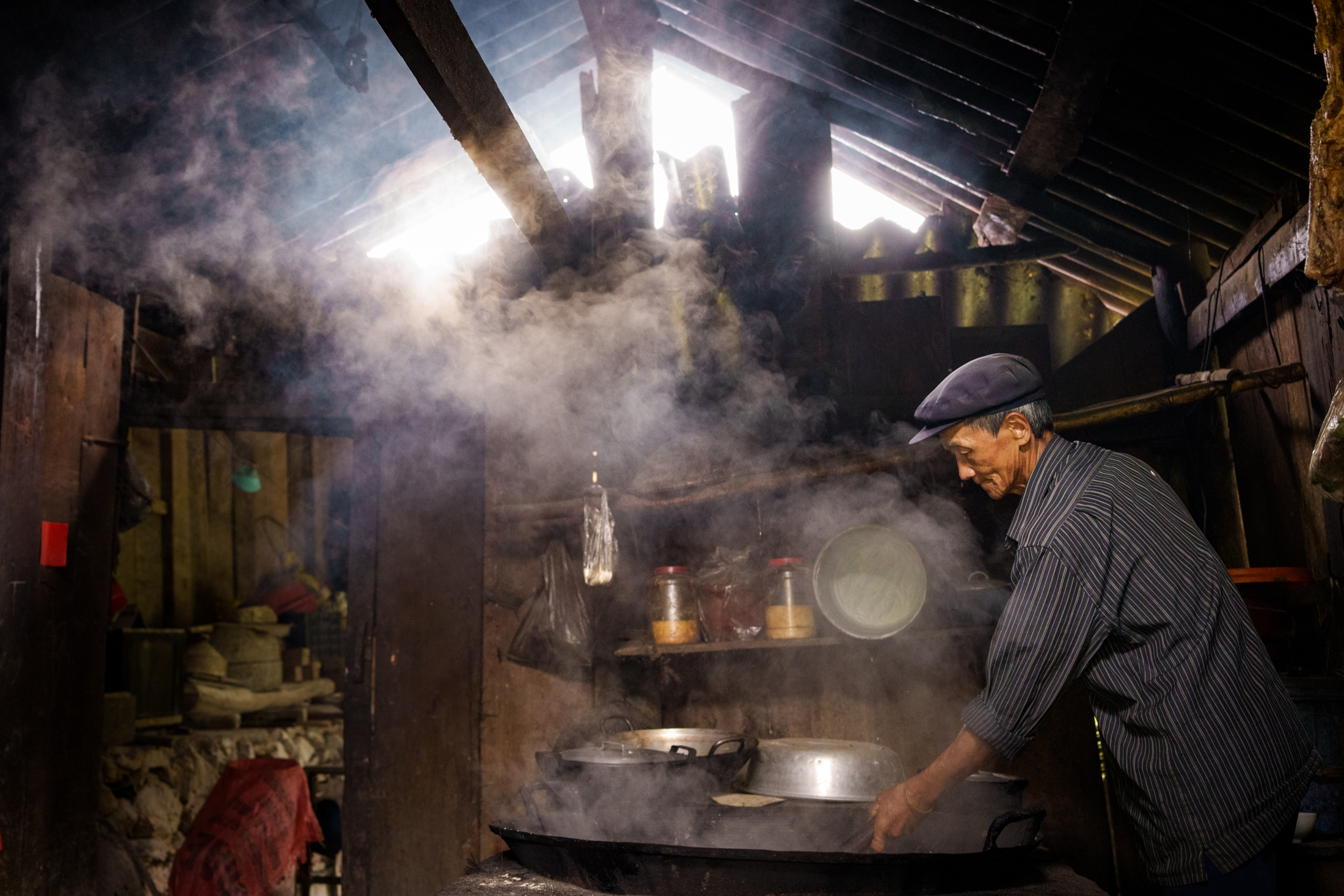 Northern Vietnam Photography: A Photographer’s Journey Beyond the Tourist Trail 25 An elderly man cooks over an open fire inside a traditional wooden home in northern Vietnam.
