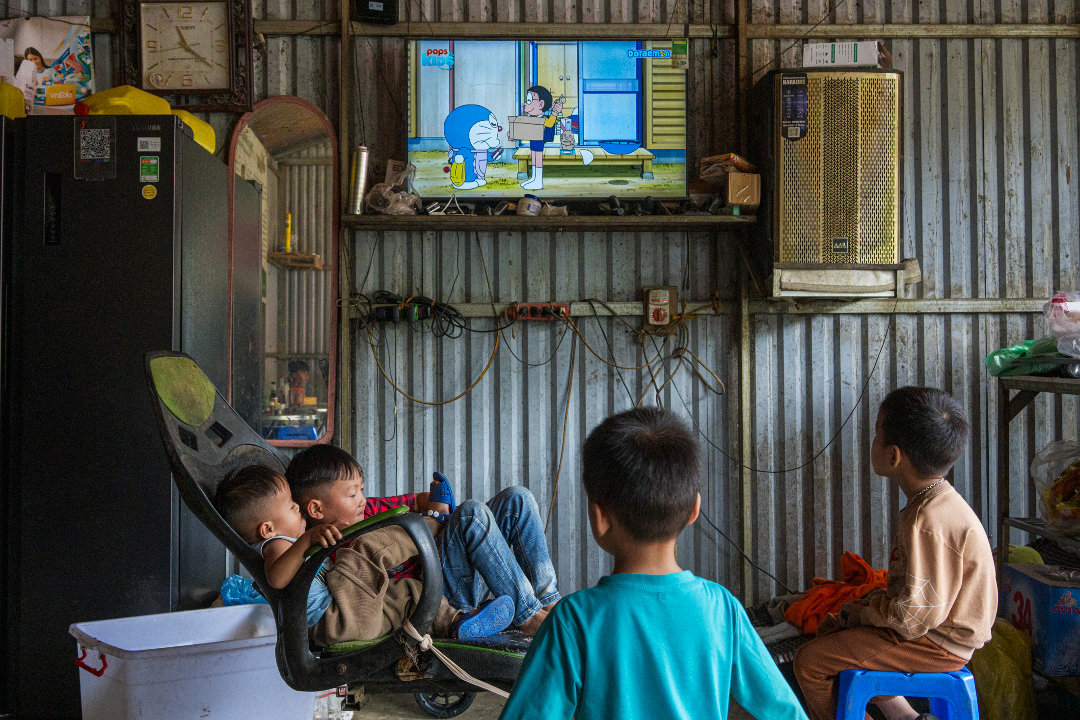 Northern Vietnam Photography: A Photographer’s Journey Beyond the Tourist Trail 10 Children watch cartoons on a television inside a simple corrugated metal home in northern Vietnam.